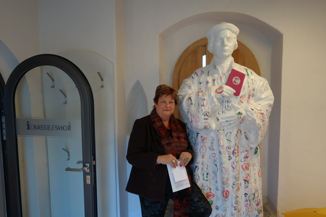 Barbara Hackenschmidt neben der Luther-Figur mit Werbung für den „Luther-Pass“.